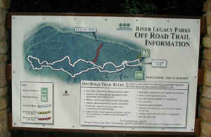 A sign with a map of the River Legacy Mountain Bike Trail