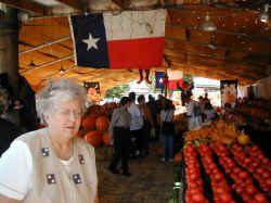 A tourist from Washington looks at tomatoes under the Texas flag in the Dallas Farmers Market.