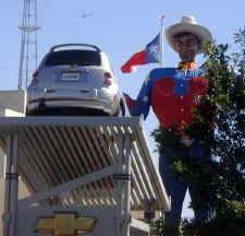 Big Tex at the Texas State Fair in Dallas looking at a car.