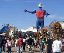 The backside of Big Tex at the Texas State Fair in Dallas standing above the crowd of Texas fairgoers.