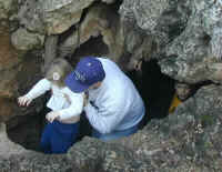 A dad leading his kids out of Outlaw Cave in Turner Falls Park.