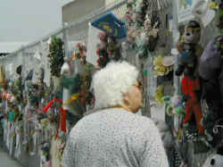 A grandma looking at the memorial of items stuck to a fence outside the Oklahoma City National Memorial.
